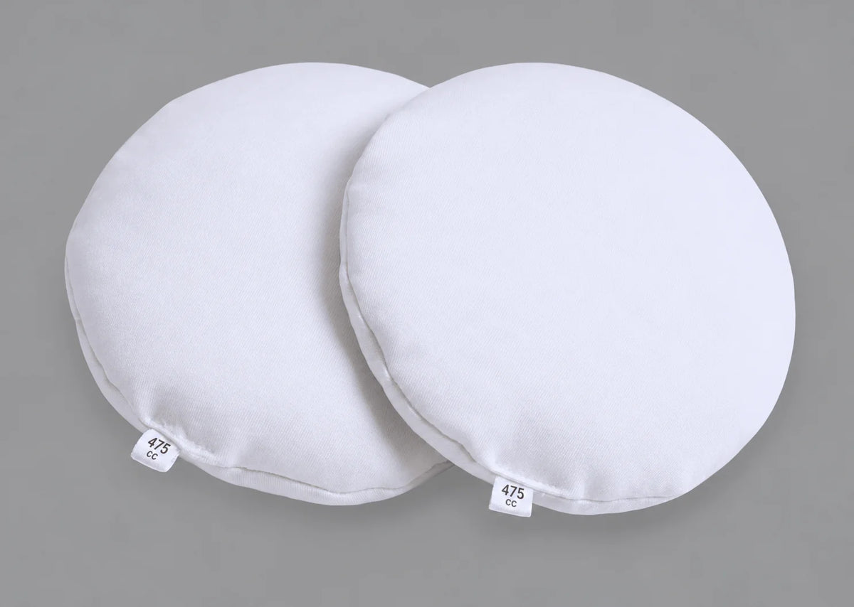 Pair of Oumènta 475cc breast implant sizers in white fabric for trying breast implant sizes at home before surgery.